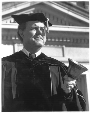 Park serving as faculty marshal in academic processions, holding a bell.