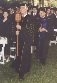 Grand Marshal Dr. Leland Park holds the college mace.