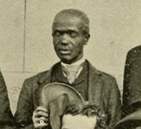 Alex, an older black man dressed formally in a jacket and tie