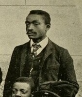Rich, a black man dressed formally in a jacket and tie.