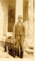 Enoch Donaldson, an older black man dressed formally in a vest standing in front of columns.