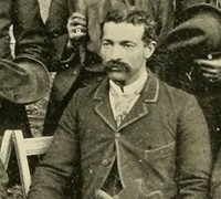 Aaron, a black man dressed formally in a jacket and tie