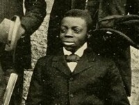 Syd, a young black man dressed formally in a jacket and tie