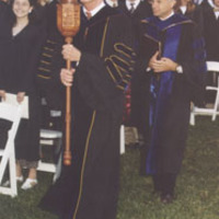 Grand Marshal Dr. Leland Park holds the college mace.